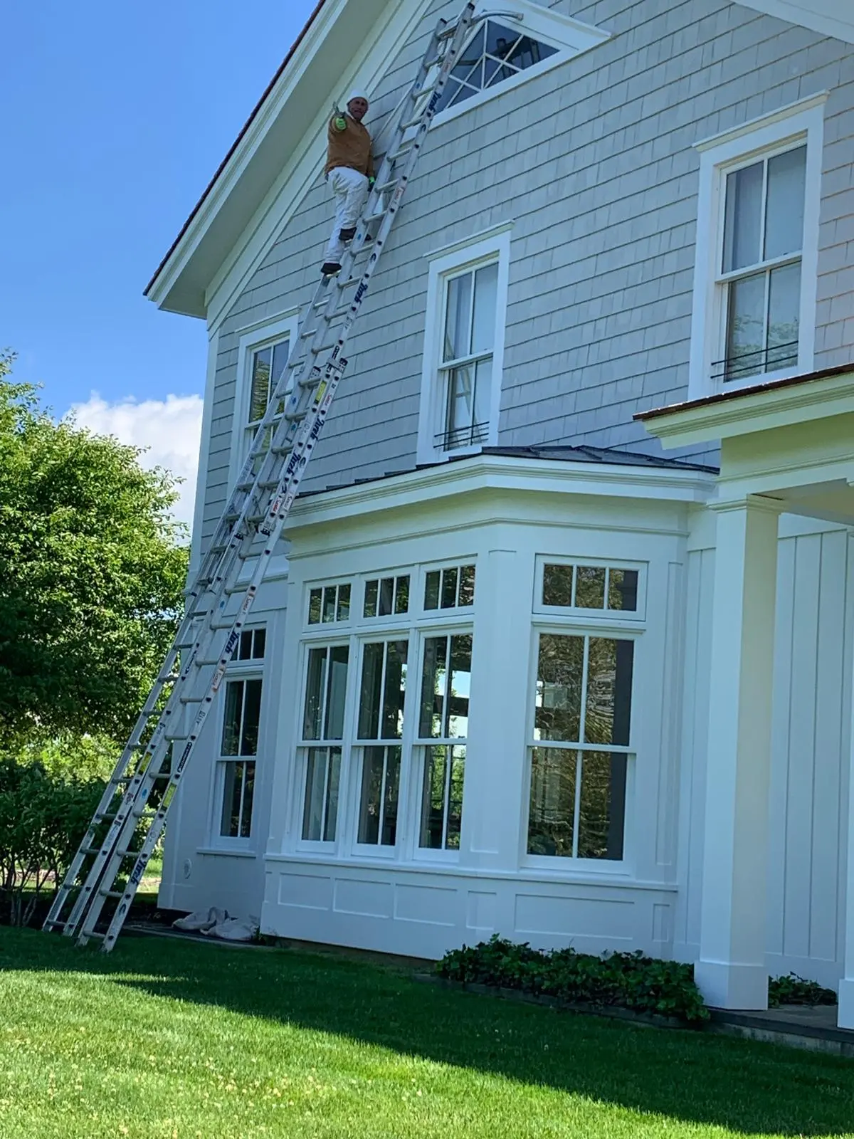 Painter at work on a ladder in East Hampton, NY